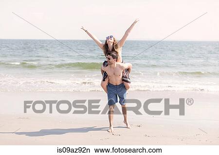 Man on beach giving woman piggyback, Coney island, Brooklyn, New York, USA View Large Photo Image Picture - Man on beach giving woman piggyback, Coney island, Brooklyn, New York, USA. Fotosearch