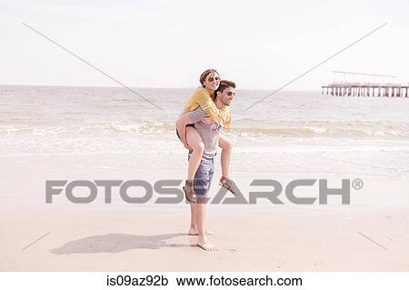Man on beach giving woman piggyback, Coney island, Brooklyn, New York, USA View Large Photo Image Stock Image - Man on beach giving woman piggyback, Coney island, Brooklyn, New York, USA. Fotosearch