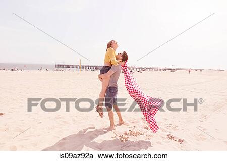Man on beach picking up woman, Coney island, Brooklyn, New York, USA View Large Photo Image Stock Image - Man on beach picking up woman, Coney island, Brooklyn, New York, USA. Fotosearch