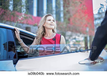 Man opening car door for city businesswoman View Large Photo Image Stock Image - Man opening car door for city businesswoman. Fotosearch