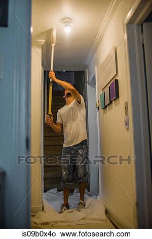 Man painting passage ceiling with paint roller View Large Photo Image Picture - Man painting passage ceiling with paint roller. Fotosearch