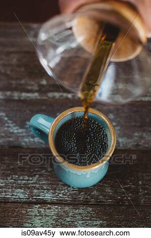 Stock Photo - Man pouring coffee from filter coffee maker. Fotosearch