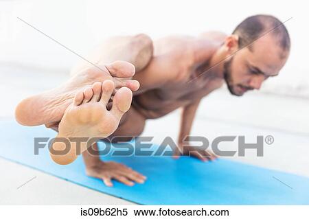 Man practicing yoga, balancing on hands with legs outstretched View Large Photo Image Stock Photography - Man practicing yoga, balancing on hands with legs outstretched. Fotosearch