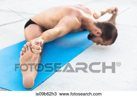 Man practicing yoga, sitting on yoga mat doing the splits and touching toes View Large Photo Image Stock Image - Man practicing yoga, sitting on yoga mat doing the splits and touching toes. Fotosearch