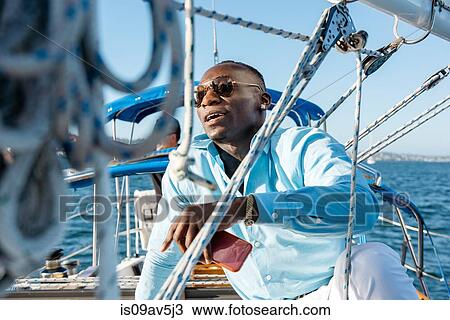 Man relaxing on sailboat View Large Photo Image Stock Image - Man relaxing on sailboat. Fotosearch
