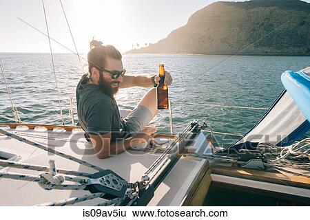 Man relaxing with beer on sailboat, San Diego Bay, California, USA View Large Photo Image Stock Photograph - Man relaxing with beer on sailboat, San Diego Bay, California, USA. Fotosearch