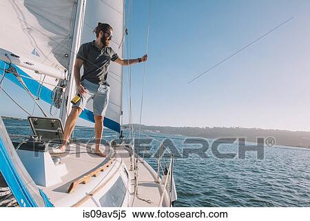 Stock Photography - Man relaxing with beer on sailboat, San Diego Bay, California, USA. Fotosearch