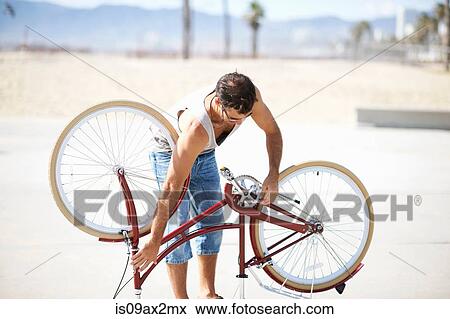 Man repairing bicycle at Venice Beach, Los Angeles, California, USA View Large Photo Image Stock Photo - Man repairing bicycle at Venice Beach, Los Angeles, California, USA. Fotosearch