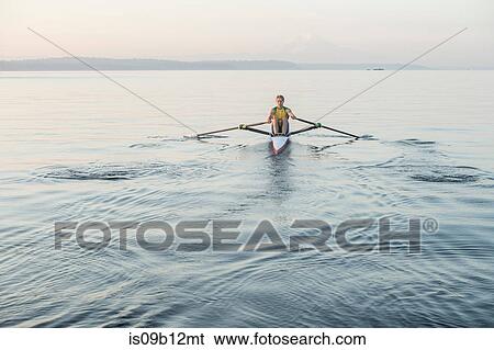 Stock Photograph - Man rowing row boat in sea around Bainbridge Island, Washington, USA. Fotosearch