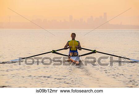Stock Photography - Man rowing row boat in sea around Bainbridge Island, Washington, USA. Fotosearch