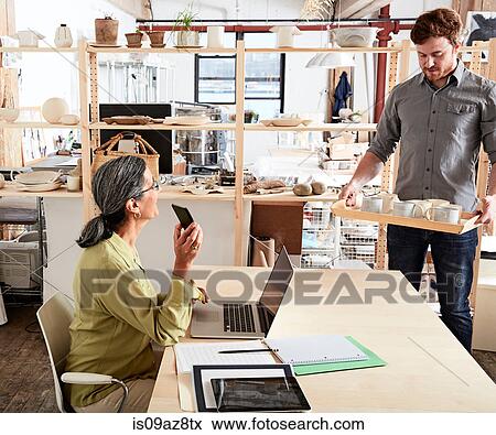 Man showing colleague tray of ceramics View Large Photo Image Stock Photo - Man showing colleague tray of ceramics. Fotosearch