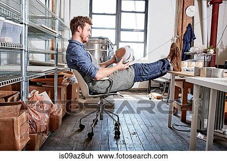 Man sitting with feet up in pottery workshop View Large Photo Image Stock Image - Man sitting with feet up in pottery workshop. Fotosearch