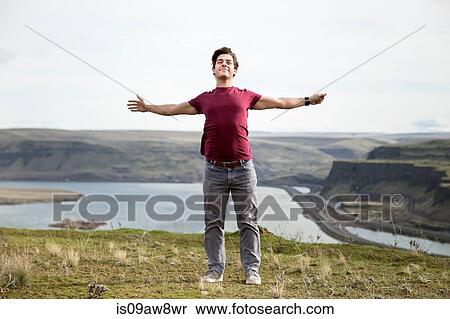 Stock Photography - Man standing on mountain top, breathing fresh air, Colombia River Gorge, Washington, USA. Fotosearch