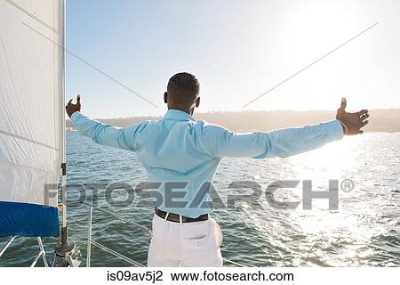 Man stretching arms on sailboat, San Diego Bay, California, USA View Large Photo Image Stock Image - Man stretching arms on sailboat, San Diego Bay, California, USA. Fotosearch