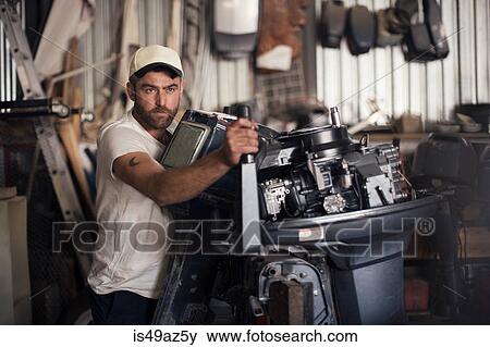 Man testing outboard motor in boat repair workshop View Large Photo Image Stock Photo - Man testing outboard motor in boat repair workshop. Fotosearch