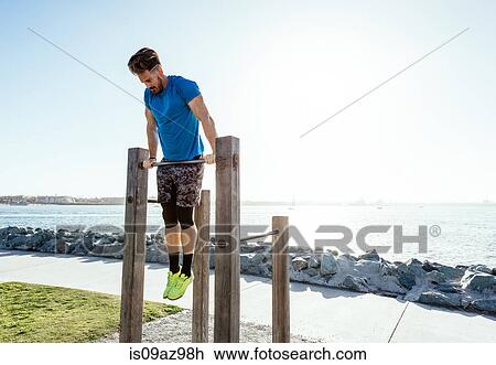 Man training, doing push ups on exercise bar at coast, downtown San Diego, California, USA View Large Photo Image Stock Image - Man training, doing push ups on exercise bar at coast, downtown San Diego, California, USA. Fotosearch