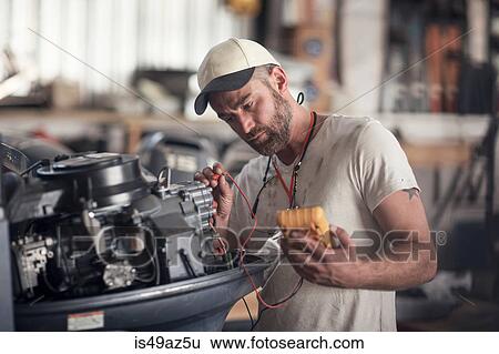 Man using machine to test outboard motor in boat repair workshop View Large Photo Image Stock Photograph - Man using machine to test outboard motor in boat repair workshop. Fotosearch