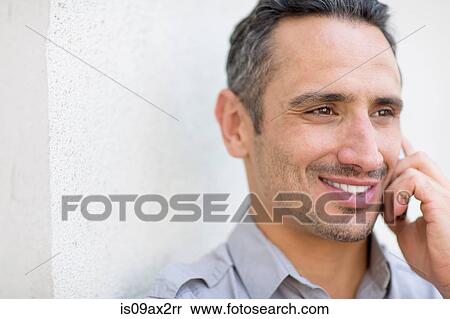 Stock Photography - Man using smartphone to make telephone call, looking away. Fotosearch