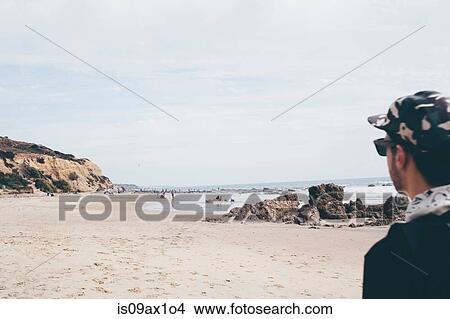 Man wearing baseball cap looking out at beach, Crystal Cove State Park, Laguna Beach, California, USA View Large Photo Image Picture - Man wearing baseball cap looking out at beach, Crystal Cove State Park, Laguna Beach, California, USA. Fotosearch
