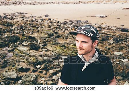 Man wearing baseball cap looking out from beach, Crystal Cove State Park, Laguna Beach, California, USA View Large Photo Image Stock Photograph - Man wearing baseball cap looking out from beach, Crystal Cove State Park, Laguna Beach, California, USA. Fotosearch
