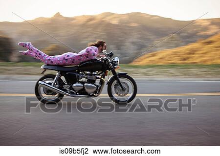 Man wearing onesie lying on front riding motorcycle, Malibu Canyon, California, USA View Large Photo Image Stock Image - Man wearing onesie lying on front riding motorcycle, Malibu Canyon, California, USA. Fotosearch