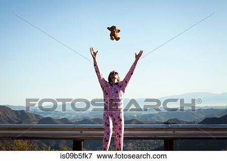 Man wearing pink onesie throwing teddy bear in mid air, Malibu Canyon, California, USA View Large Photo Image Stock Photo - Man wearing pink onesie throwing teddy bear in mid air, Malibu Canyon, California, USA. Fotosearch