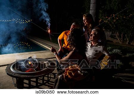 Mature adult couples watching sparkler by patio fire at night View Large Photo Image Stock Image - Mature adult couples watching sparkler by patio fire at night. Fotosearch