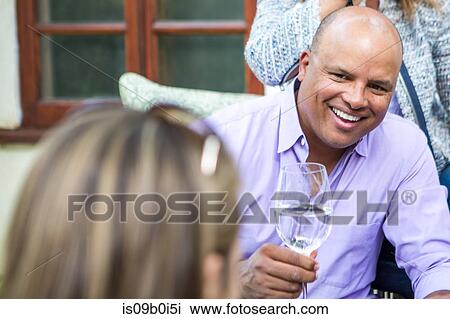 Mature adults chatting and laughing on patio at garden party View Large Photo Image Stock Image - Mature adults chatting and laughing on patio at garden party. Fotosearch