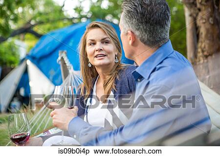 Mature couple chatting on hammock at garden party View Large Photo Image Stock Photography - Mature couple chatting on hammock at garden party. Fotosearch