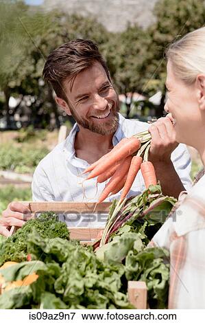 Mature couple holding crate of fresh vegetables in garden View Large Photo Image Stock Photo - Mature couple holding crate of fresh vegetables in garden. Fotosearch