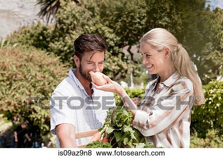 Mature couple in garden, woman holding up fresh onion for man to smell View Large Photo Image Stock Photo - Mature couple in garden, woman holding up fresh onion for man to smell. Fotosearch