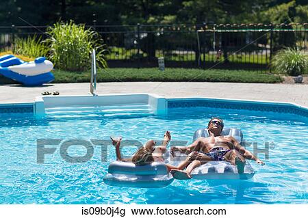Mature couple in swimming pool, relaxing on inflatables View Large Photo Image Stock Image - Mature couple in swimming pool, relaxing on inflatables. Fotosearch