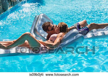 Mature couple in swimming pool, relaxing on inflatables, kissing View Large Photo Image Stock Image - Mature couple in swimming pool, relaxing on inflatables, kissing. Fotosearch