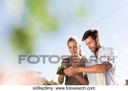 Mature couple inspecting plant leaf in garden View Large Photo Image Stock Photo - Mature couple inspecting plant leaf in garden. Fotosearch