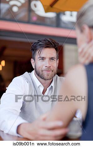Mature couple sitting outdoors, face to face, smiling View Large Photo Image Picture - Mature couple sitting outdoors, face to face, smiling. Fotosearch