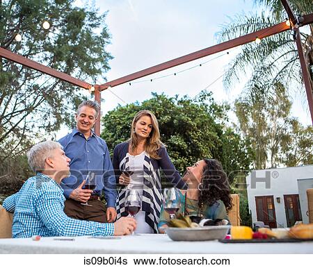 Mature couples chatting at garden party table View Large Photo Image Stock Photograph - Mature couples chatting at garden party table. Fotosearch