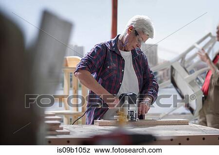 Mature female carpenter using sander in furniture making workshop View Large Photo Image Stock Photo - Mature female carpenter using sander in furniture making workshop. Fotosearch