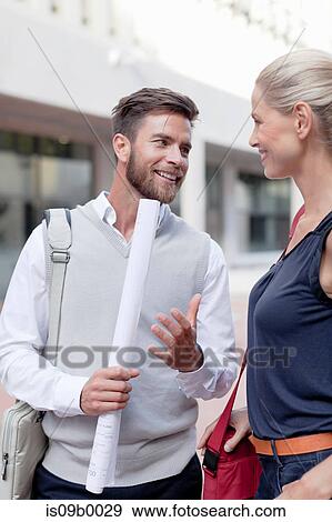 Mature man and woman outdoors, having discussion, man holding rolled up documents View Large Photo Image Stock Photo - Mature man and woman outdoors, having discussion, man holding rolled up documents. Fotosearch