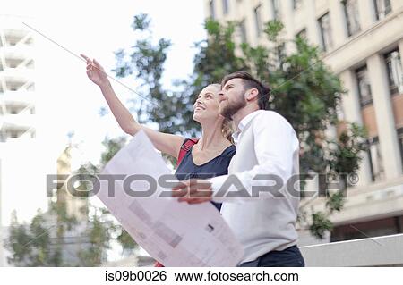 Mature man and woman outdoors, holding blueprints, having discussion View Large Photo Image Stock Photograph - Mature man and woman outdoors, holding blueprints, having discussion. Fotosearch