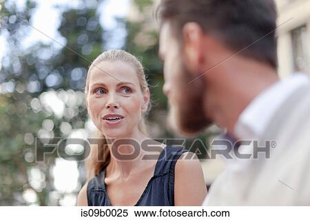 Mature man and woman sitting outdoors, having discussion View Large Photo Image Stock Photography - Mature man and woman sitting outdoors, having discussion. Fotosearch