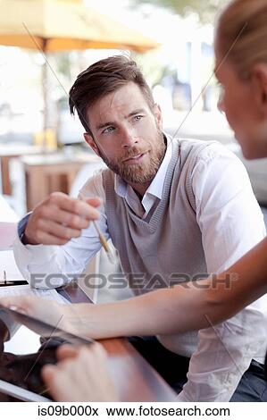 Mature man and woman sitting outside cafe, having discussion View Large Photo Image Stock Photo - Mature man and woman sitting outside cafe, having discussion. Fotosearch