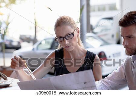 Mature man and woman, sitting outside cafe, looking at documents View Large Photo Image Stock Photography - Mature man and woman, sitting outside cafe, looking at documents. Fotosearch