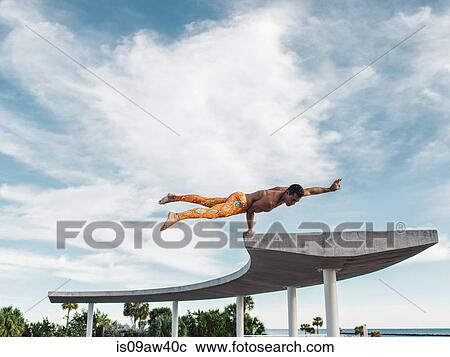 Stock Image - Mature man balancing on structure, South Pointe Park, South Beach, Miami, Florida, USA. Fotosearch