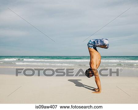 Stock Photo - Mature man doing handstand on beach, South Pointe Park, South Beach, Miami, Florida, USA. Fotosearch