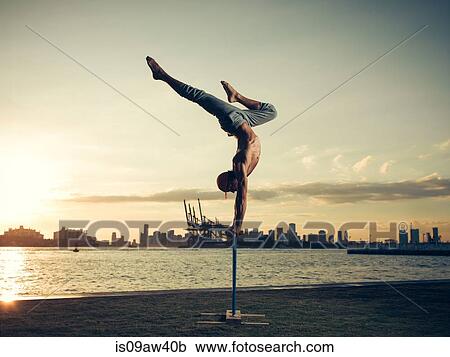 Mature man doing handstand on pole, South Pointe Park, South Beach, Miami, Florida, USA View Large Photo Image Stock Image - Mature man doing handstand on pole, South Pointe Park, South Beach, Miami, Florida, USA. Fotosearch
