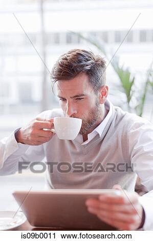 Mature man sitting in cafe, drinking coffee, using digital tablet View Large Photo Image Stock Image - Mature man sitting in cafe, drinking coffee, using digital tablet. Fotosearch