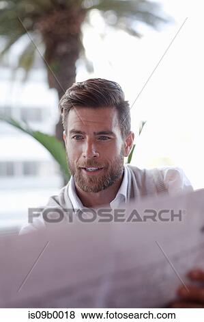 Mature man, sitting outside cafe, looking at blueprints View Large Photo Image Stock Photo - Mature man, sitting outside cafe, looking at blueprints. Fotosearch