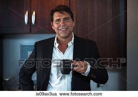 Mature man wearing shirt and suit jacket holding coffee cup looking at camera smiling View Large Photo Image Stock Image - Mature man wearing shirt and suit jacket holding coffee cup looking at camera smiling. Fotosearch