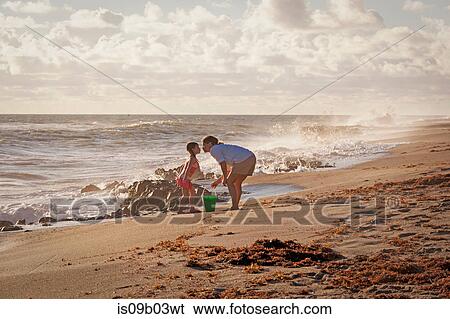 Stock Photograph - Mature woman and daughter puckering for a kiss on beach, Blowing Rocks Preserve, Jupiter Island, Florida, USA. Fotosearch