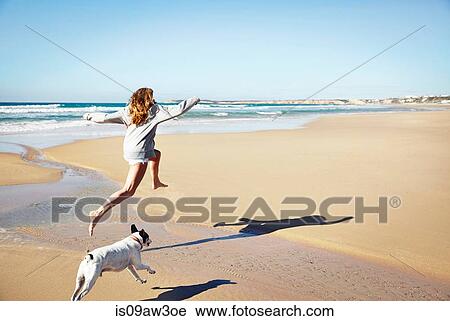 Mature woman and dog leaping over water on beach, Conil de la Frontera, Spain View Large Photo Image Stock Image - Mature woman and dog leaping over water on beach, Conil de la Frontera, Spain. Fotosearch